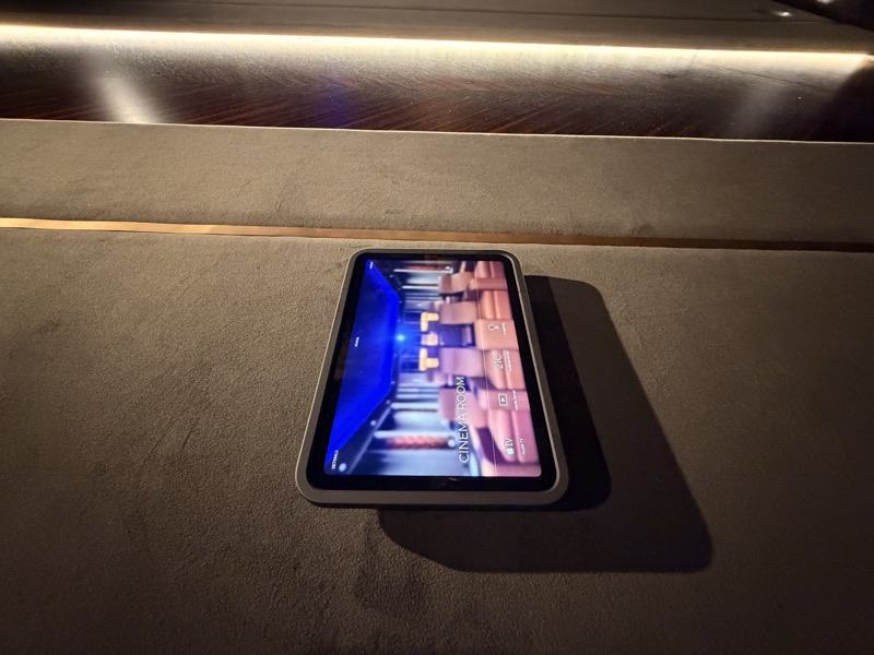 A cinema touchscreen brings media sources, room temperature and lighting into one interface.
