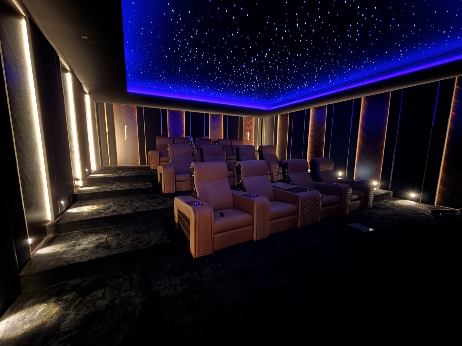 Private cinema with tiered seating and a blue star ceiling